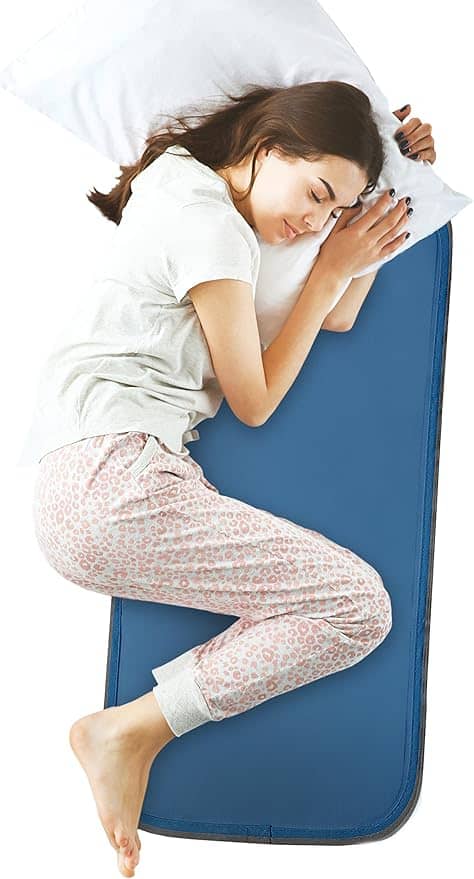 Mulher deitada sobre uma almofada refrescante para aliviar as ondas de calor da menopausa no verão